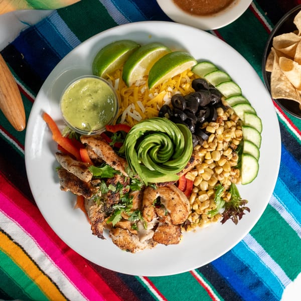 El Coronado's chicken salad with avocado, corn, olives, cheese, cucumber, and lime on a colorful serape.